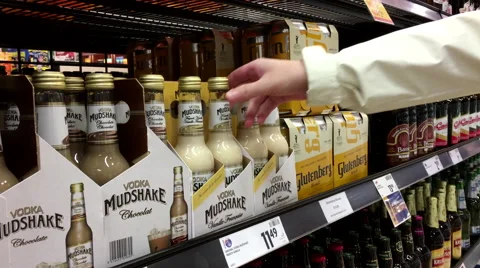 A hand takes bottles of Vodka mudshake french vanille from the shelf Stock Footage 61281604