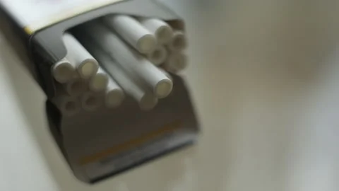 A hand takes a cigarette from an open pack on the table. bad habit, risk of Stock Footage 239274053