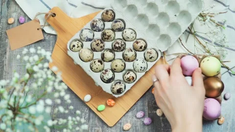 The hand takes a colored Easter egg on the table. The concept of preparing for Stock Footage 237108802