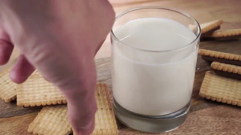 Hand takes crispy cookies with a pattern from a heap on a wooden table with a Stock Footage 161154492