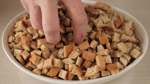 Hand takes a handful of toasted bread croutons. Stock Footage 328477270