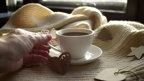 Hand takes mug black coffee wrapped warm scarf with wooden Christmas decorations Stock Footage 219878369