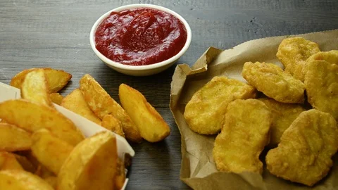 Hand takes nuggets and dips it in tomato sauce Stock Footage 123402477