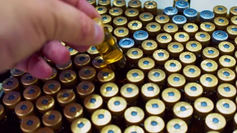 A hand takes one of many identical vials for quality control. 스톡 동영상 294058554