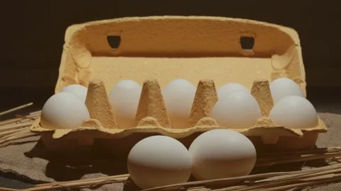 Hand takes one from two eggs white packed in carton 4K video 動画素材 130884133