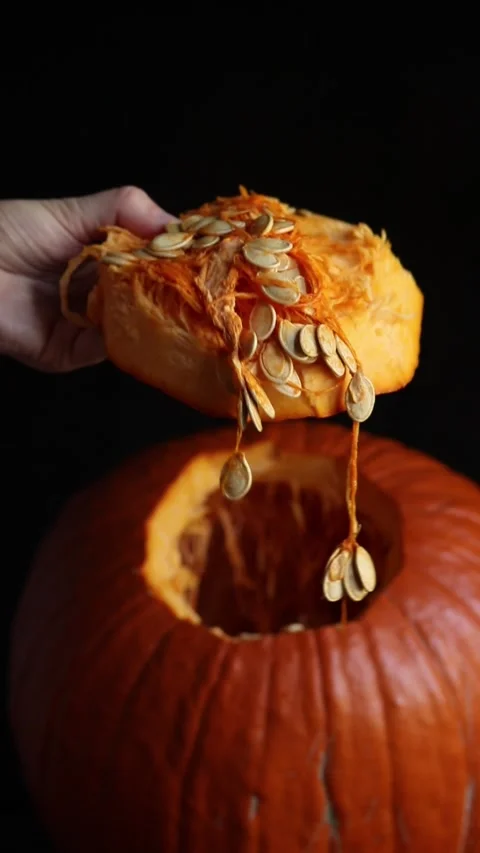 A hand takes out the pulp and seeds from a large pumpkin Video stock 347608646