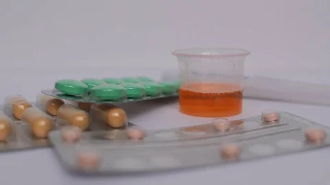 Hand takes pills from white table. Pharmaceutical, medical, medicament concept 스톡 동영상 75669860