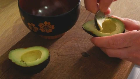 Hand that takes the pulp with a spoon from a avocado Stock-Footage 112346057