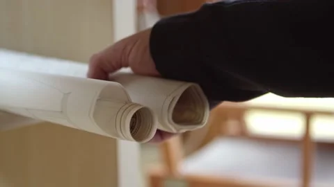 A hand takes a rolled-up construction plan off the shelf. Close-up shot Stock Footage 173243695