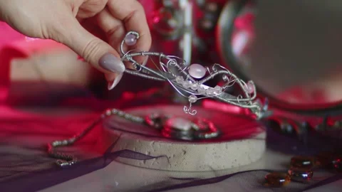 A hand takes a silver tiara from a stand Stock Footage 274643705