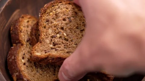 Hand takes a slice of cereal rye bread made from dark flour 스톡 동영상 254395126