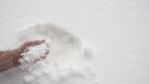 A hand takes in slow motion white snow Stock Footage 165595673