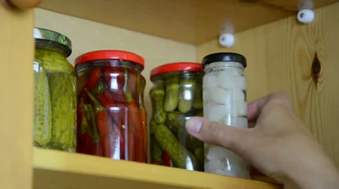 Hand takes small jars pickled onion garlic and capers from shelf Stock Footage 32826638