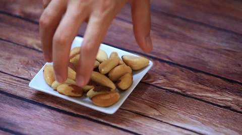 Hand takes some almonds nuts on wooden table Stock Footage 34957273