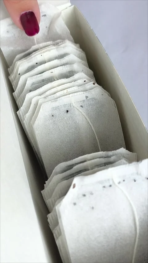 A hand takes a tea bag from a package. Vídeo Stock 311975107