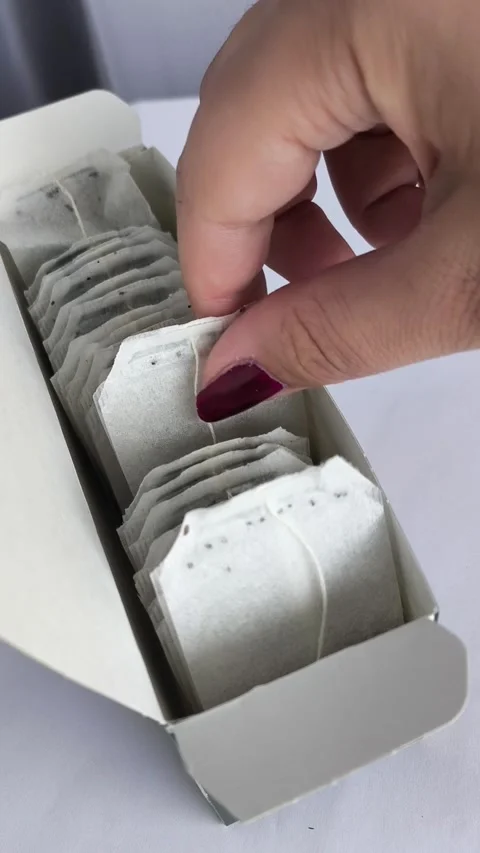 A hand takes a tea bag from a package. Video stock 311975110