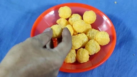 A hand taking and breaking a round snack from an orange plate. Sweet snacks Stock Footage 317509230
