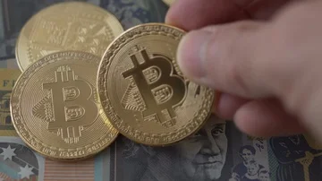 A hand taking away then replacing a Bitcoin coin Video stock 85746363