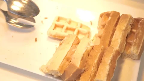 Hand taking belgian waffles lying on white plate on buffet in hotel restaurant Stock Footage 106610649