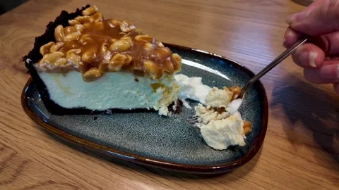 Hand Taking a Bite of Cheesecake with Fork in Cozy Cafe, Slow Motion Stock Footage 327824037