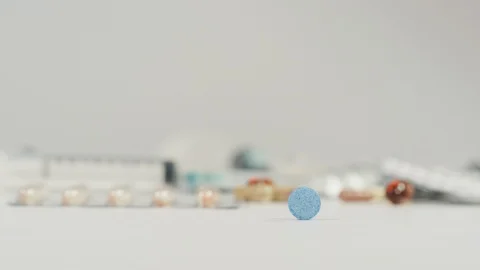 Hand taking a blue pill Stock Footage 99750220