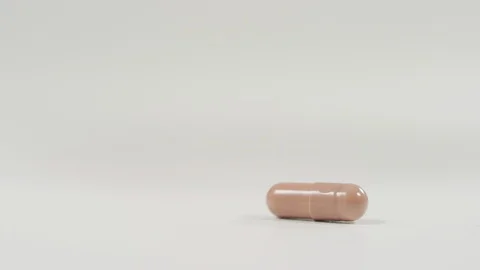 Hand taking a brown capsule Stock Footage 99750287
