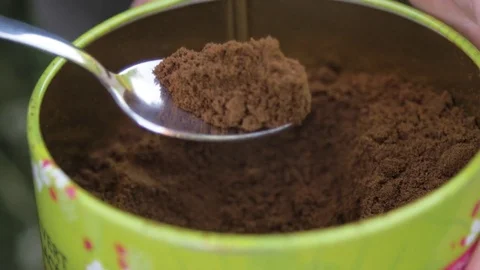 Hand taking cocoa powder with spoon Stock Footage 71560579