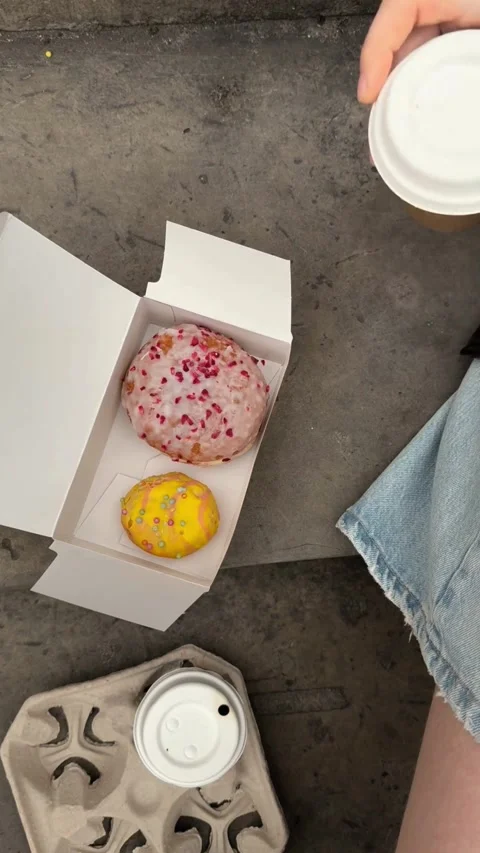 Hand taking coffee cup next to donuts in box Stock-Footage 331772609
