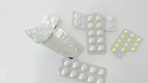 Hand taking daily dose of pills from blister packs for medical treatment. A.. Stock Footage 335141520