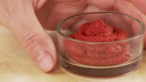 A hand taking a dish of tomato puree Stock Footage 24636430