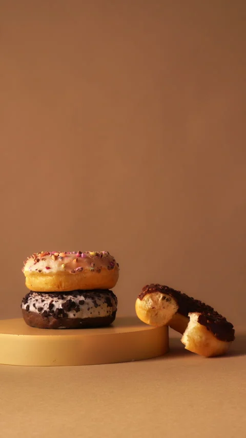 Hand Taking Donut from Stack with Bite Detail on Minimal Podium 動画素材 331232397