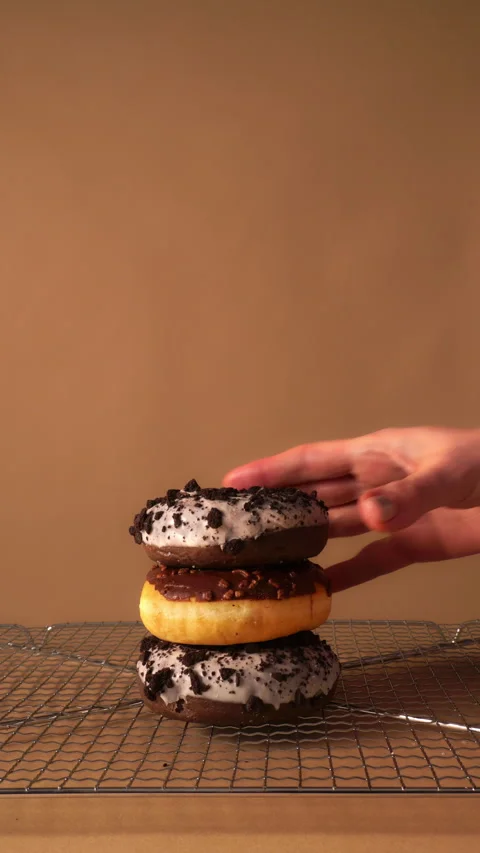 Hand Taking Donuts One by One from Stack on Cooling Rack Background Stock Footage 331232445