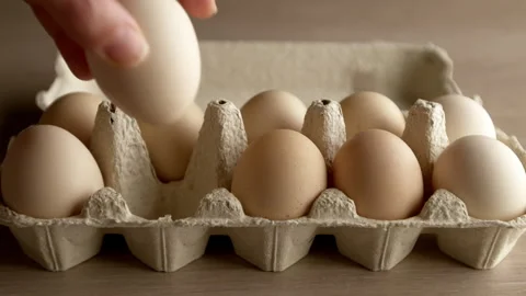 A hand taking a fresh chicken egg from a tray. Close-up. Stock Footage 314269092