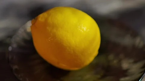 Hand taking a fresh green lime from a saucer with a lemon Stock Footage 311891417