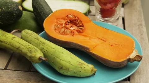 Hand taking a half of a butternut squash from a plate Stock Footage 160258993