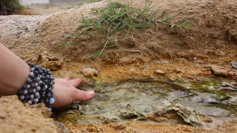 Hand taking healing mud. Thermal spring Rupite, Bulgaria. HD video. Stock Footage 81456203