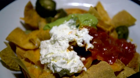 Hand taking nacho with melted cheese from plate Stock Footage 57046850