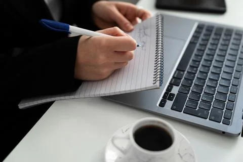 Hand Taking Notes While Working on Laptop Stock Photos