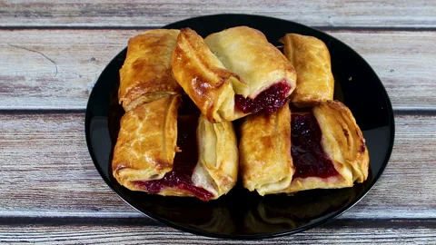 Hand taking one delicious pastry stuffed with cherries served on the plate Stock Footage 138157729