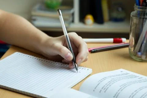 A hand taking or writing notes from a book, close up Stock Photos