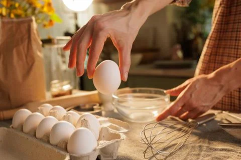 Hand taking out egg from egg carton in kitchen Stock Photos