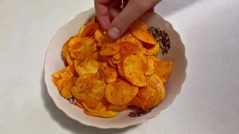 Hand Taking a Paprika Potato Chip from a Bowl Stock Footage 344577501