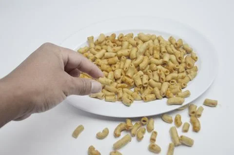 Hand taking a piece of macaroni Stock Photos
