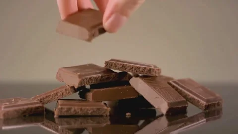 Hand Taking Piece of Milk Chocolate Close Up Broken Chocolate Bar on Beige Vídeo Stock 331774098
