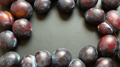 Hand taking plum from copy space in the middle of black background with plums Stock Footage 65419205