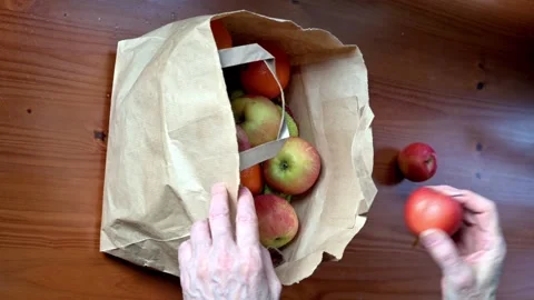 Hand Taking Red Apples From Brown Paper Grocery Bag Indoors At Home Desk Stock Footage 331902005