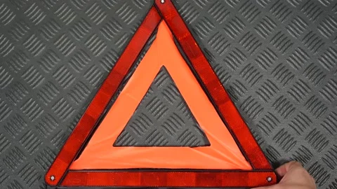 Hand taking red triangle warning sign laying on black plastic rubber mat Stock Footage 170603751