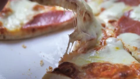 Hand taking salami pizza slice via spatula. Hot melted cheese is stretching Video stock 216965980