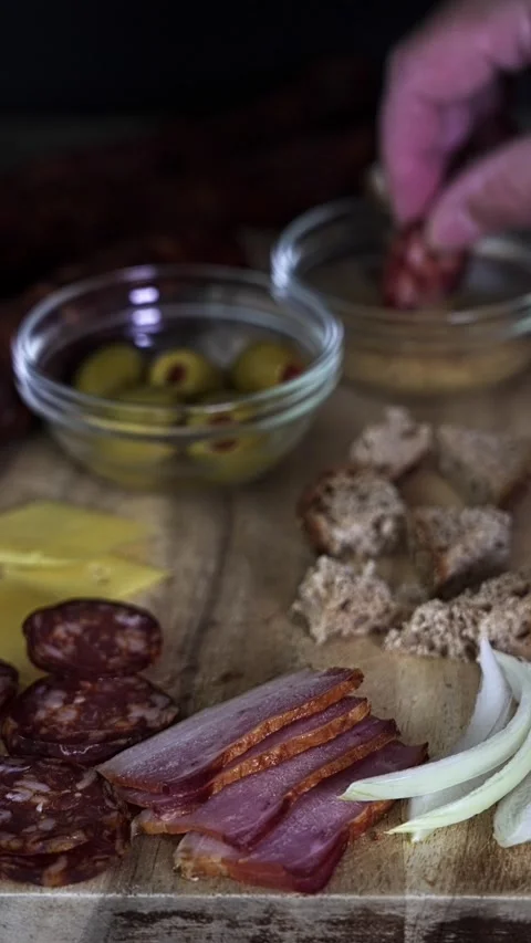 Hand taking sausage slice from chopping board with bread. 스톡 동영상 324835939