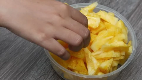 Hand taking sliced pineapple fruit in transparent plastic container, concep.. Stock Footage 244915469
